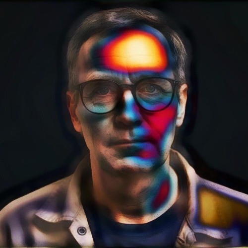 So Normal cover: a man in glasses, his face washed in red, blue and gold light, against a dark background
