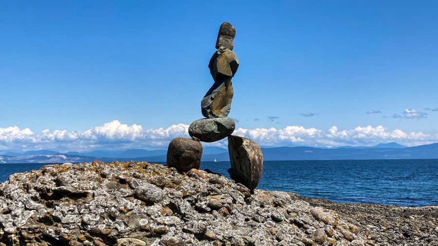 A balanced stack of stones on a rocky shore above the sea